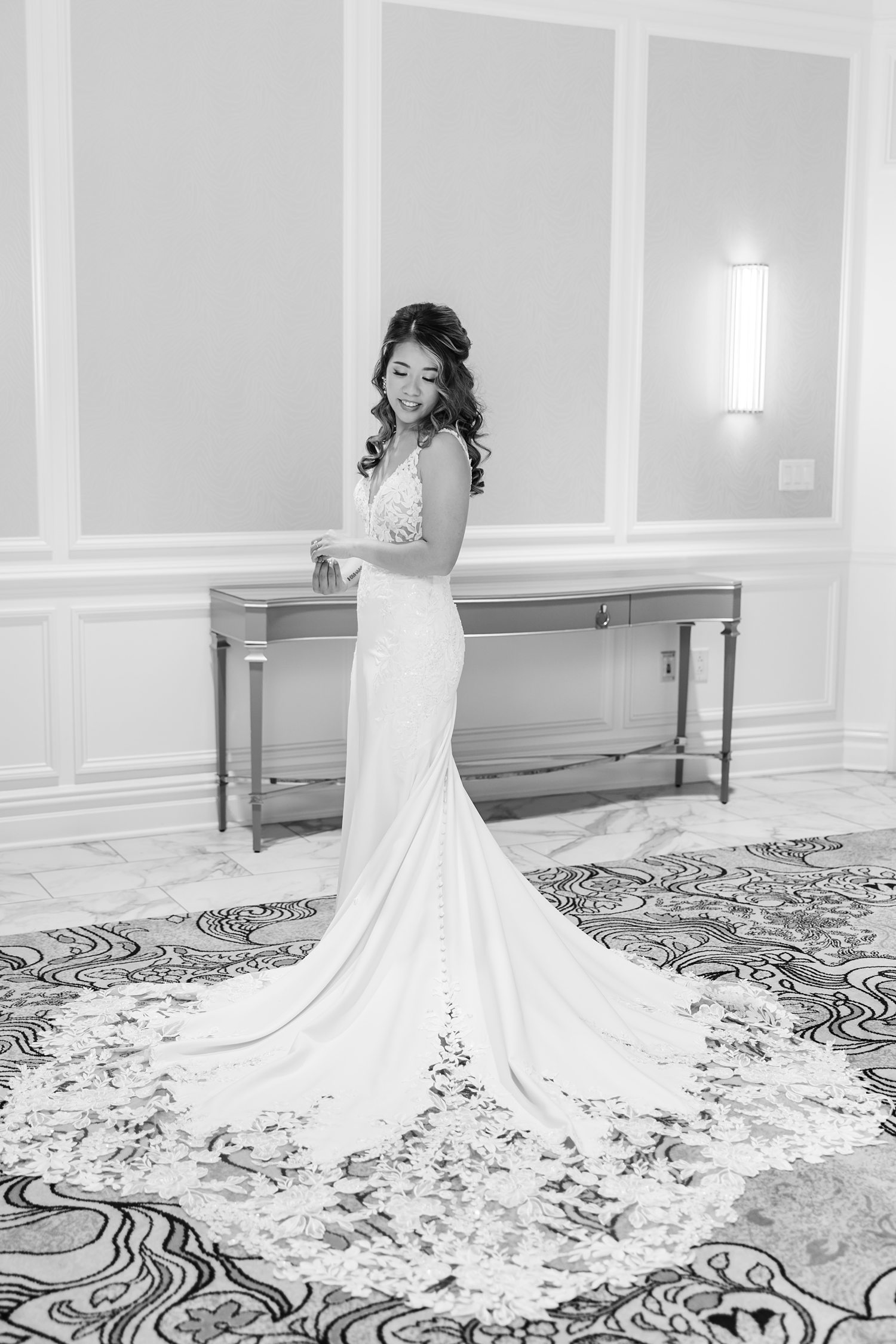 Black and white portrait of bride posing with dramatic wedding train