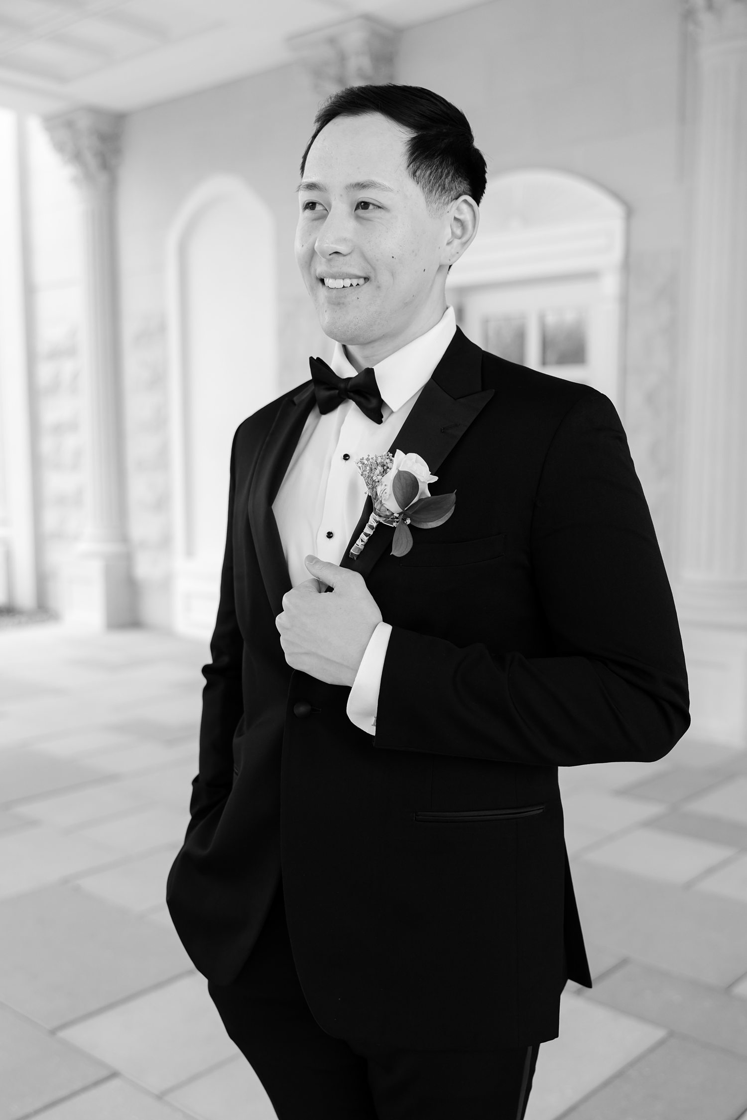 Groom smiling in classic tuxedo during luxury wedding preparation
