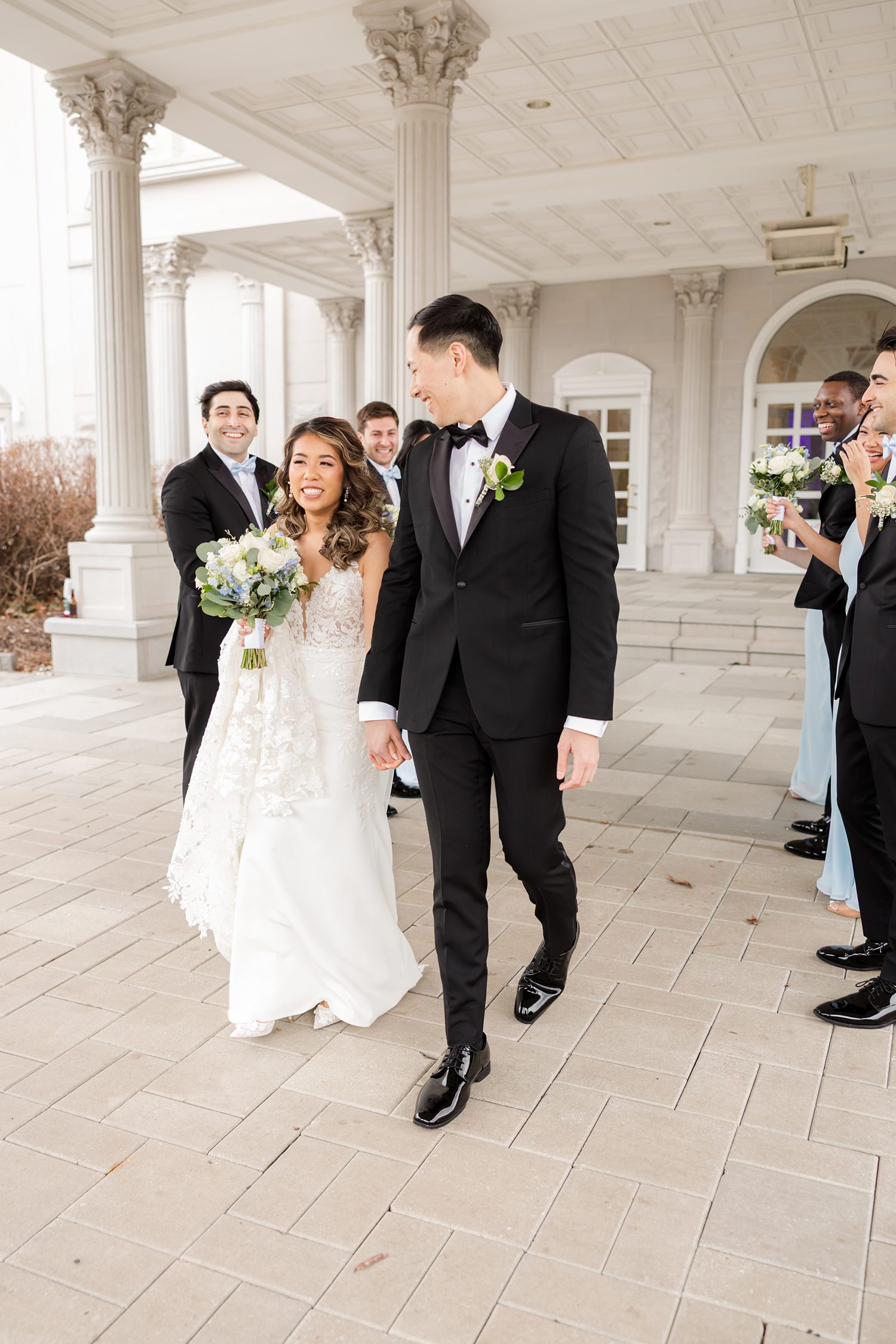 Bride and groom walking with wedding party after ceremony celebration