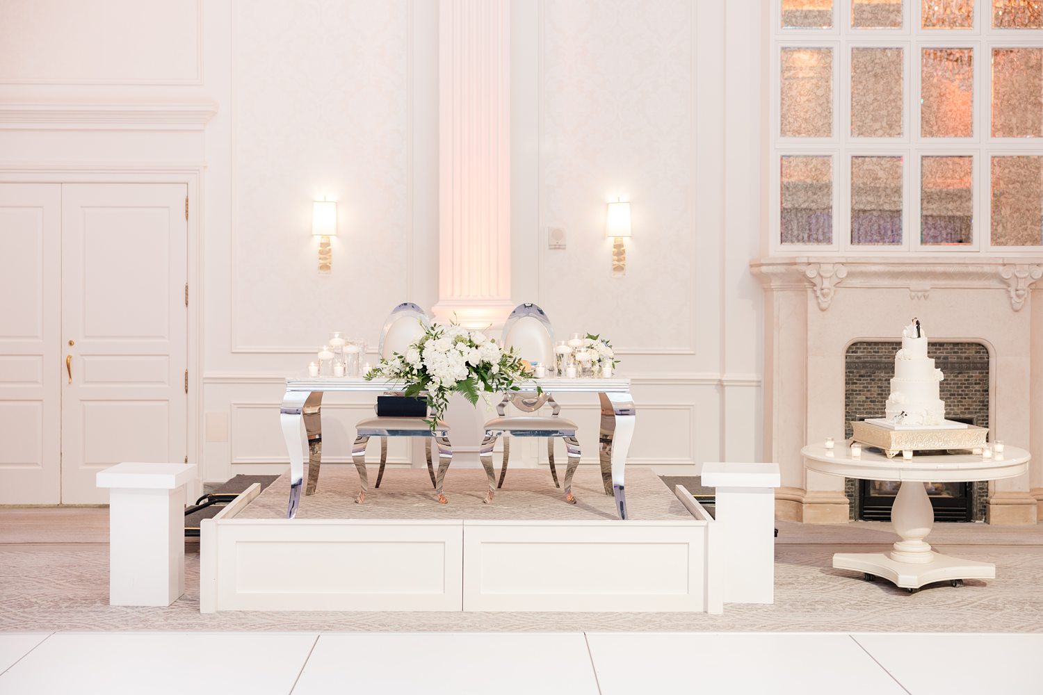Luxury wedding sweetheart table with candles and white floral centerpieces