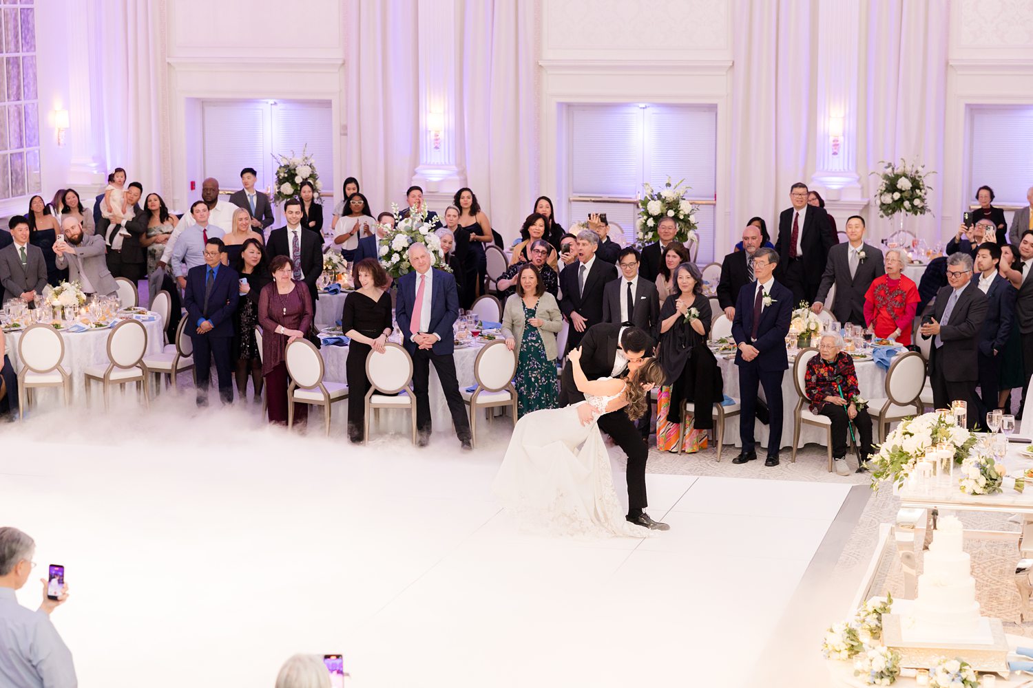 Wedding guests gathered around dance floor during lively reception